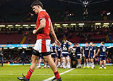 Teddy Williams walks past as Scotland players celebrate with the Doddie Weir Cup